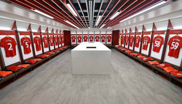 Liverpool FC home dressing room with shirts hung above the benches
